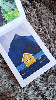 two pictures of houses on top of a rug next to each other, one with a yellow house in the middle