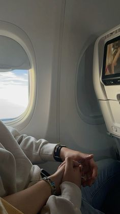 a person sitting in an airplane seat with their feet on the ground and looking out the window