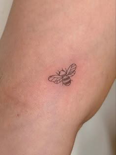 a small bee tattoo on the left thigh