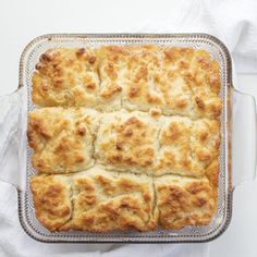 a casserole in a glass baking dish on a white table with napkins