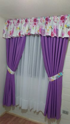 a window with purple curtains and flowers on it