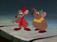 two cartoon mouses standing on top of a bed in a room with no sheets