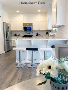 a kitchen with white cabinets and an island in front of the stove top oven is shown