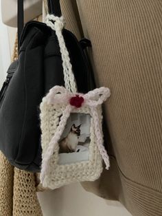 a purse hanging on the back of a chair with a cat picture attached to it