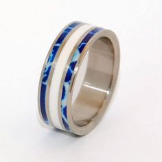 a wedding ring with blue and white marble inlays on the inside of it