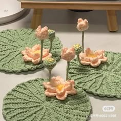 three crocheted flower coasters sitting on top of a table