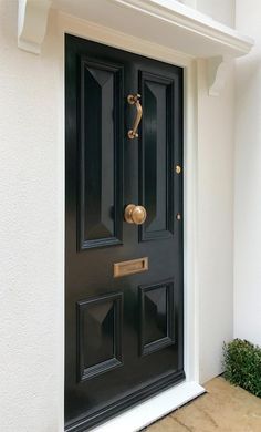 a black front door with brass handles