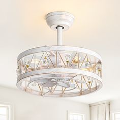 a chandelier hanging from the ceiling in a room with white walls and windows