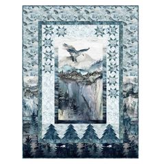 a quilt with an eagle flying over a mountain and trees on the side, in blue tones