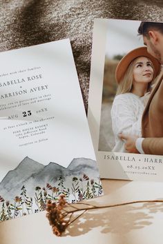 two wedding cards with an image of a man and woman in the mountains on them