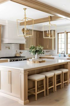 a kitchen island with stools and lights hanging from it's ceiling over the counter