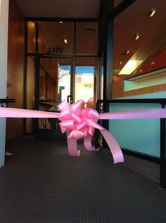 a pink ribbon tied to the front door of a building