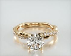 a yellow gold engagement ring with a round cut diamond in the center and side stones on each band