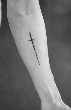 a cross tattoo on the left inner arm