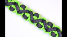 a close up of a green and black braid on a white background with the end knoted together