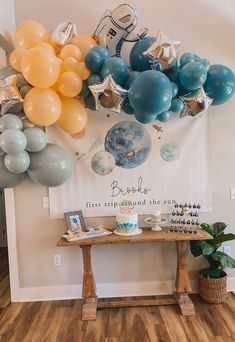 balloons are hanging from the wall above a table