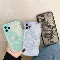 two cases with dragon designs on them are sitting next to each other in front of a white wall