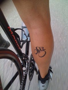 a close up of a person on a bike with a tattoo on their leg and foot