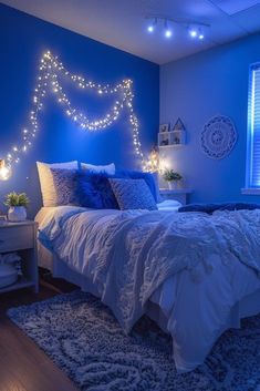 a bedroom with blue walls and lights on the headboard is lit up by string lights