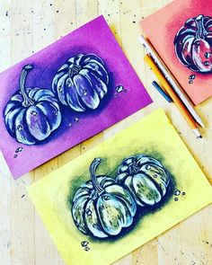 three paintings of pumpkins are on the table