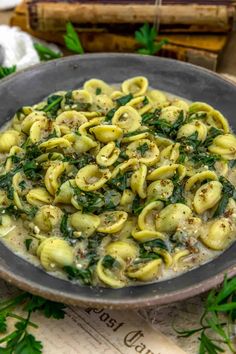 a bowl filled with pasta and spinach on top of a table