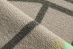 a close up view of a rug with different colors and patterns on it, including green