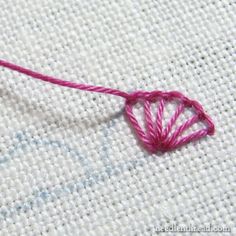 a close up of a piece of cloth with a crochet heart on it