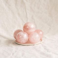 some pink marbles are on a white plate