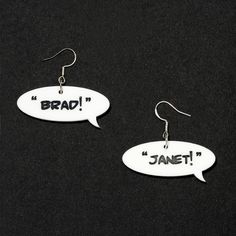 two white earrings with black letters that say, brad and janet on the side