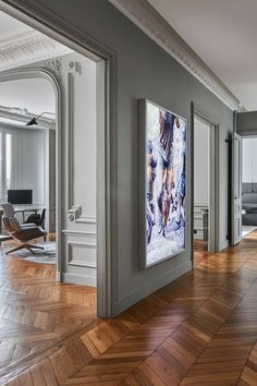 an empty room with wood floors and paintings on the wall