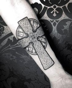 a person with a cross tattoo on their arm