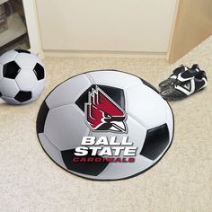 two soccer balls sitting on the floor next to a ball that says ball state cardinals