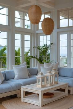 a living room filled with furniture and lots of windows covered in wicker hanging from the ceiling