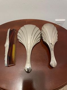 two pieces of art deco hair combs on a table