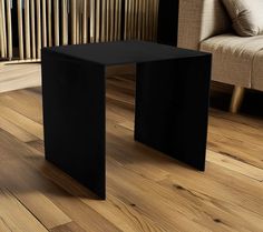 a black table sitting on top of a wooden floor