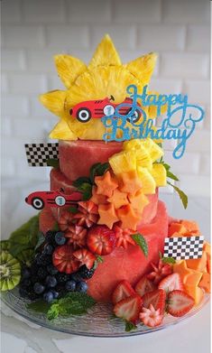 a birthday cake with fruit and flowers on top is decorated like a pineapple car