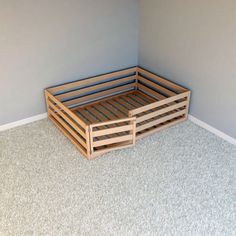 a wooden bed frame sitting on top of carpeted floor next to a blue wall