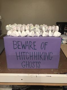 a purple box with white stuffed animals in it that says beware of highhiking ghosts