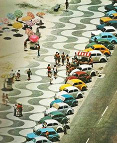 an aerial view of many cars parked in a parking lot with people walking on the sidewalk