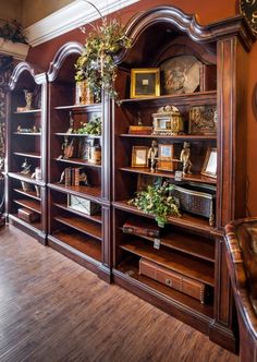 an old fashioned bookcase with many books and plants on it in a living room