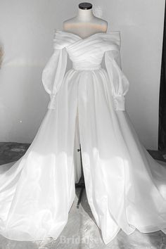 a white wedding dress on display in a room with a mannequin's head