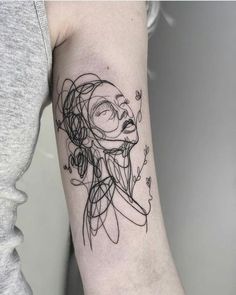 a woman's arm with a black and white line work tattoo on the left upper arm