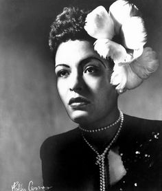 an old black and white photo of a woman with flowers in her hair