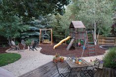 a backyard with a swing set, table and chairs