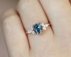 a woman's hand with a blue and white diamond ring