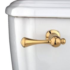 a close up of a toilet with the lid closed and gold handle on it's side