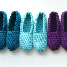 four crocheted slippers lined up next to each other