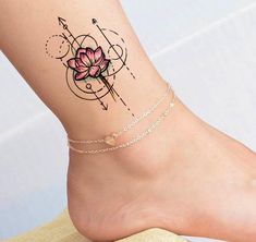 a woman's foot with a pink flower tattoo on it and an arrow in the middle