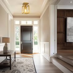 an entryway with stairs leading up to the front door, and a large rug on the floor