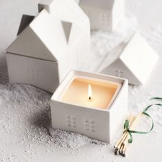 a candle is sitting in a small white box on the ground next to some matches